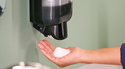 Tork milde handschuimzeep met hand die onder dispenser beweegt