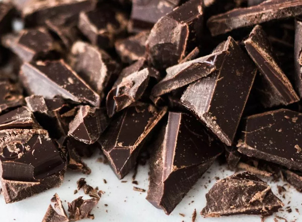 Stapel chocolade met losse cacao op de achtergrond