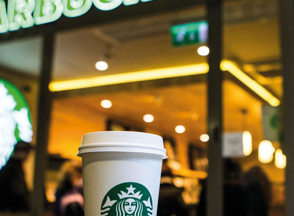 Sfeerbeeld van een to-go cup Starbucks koffie bij een Starbucks filiaal